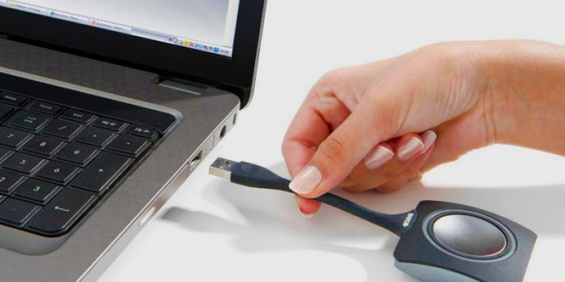 Eine Hand die das ClickShare mit einen Laptop verbindet