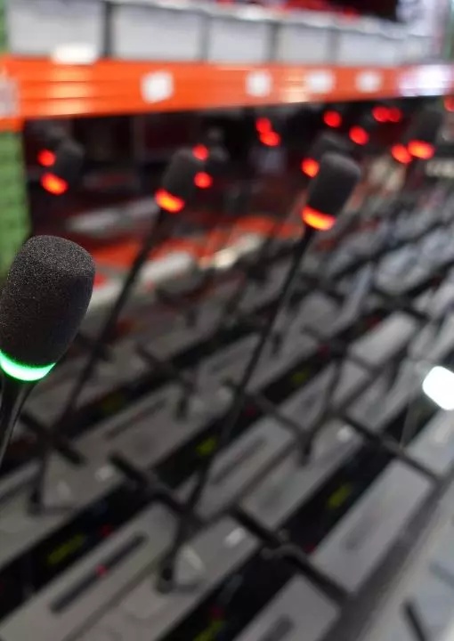 Nahaufnahme Televic-Mikrofone in Reihe mit grünen und roten LED-Indikatoren