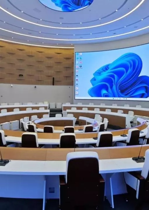 Moderner Parlamentssaal mit Televic-Konferenzeinheiten in großer Installation
