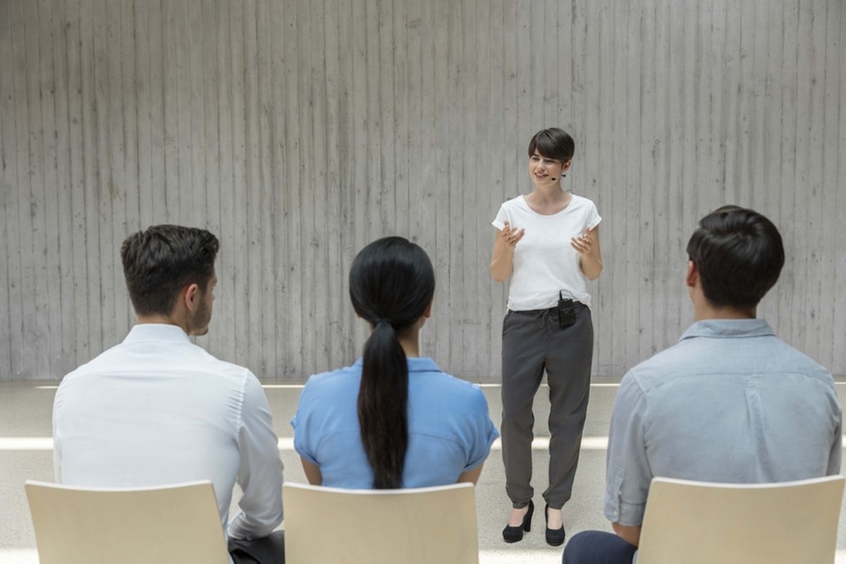 Vortragender mit drahtlosem Unite-Mikrofon vor sitzendem Publikum